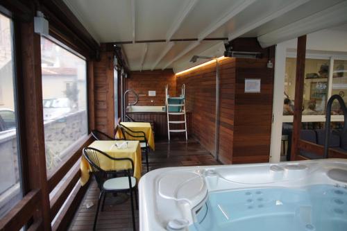 eine Badewanne in einem Zimmer mit Tisch und Stühlen in der Unterkunft Hotel Aros in Rimini