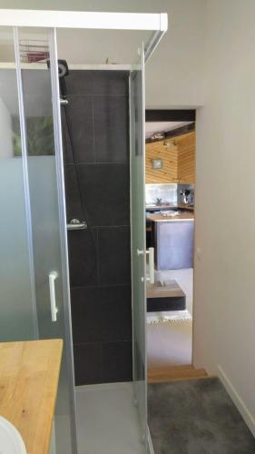 - une porte de douche en verre dans une chambre avec une cuisine dans l'établissement Le Cabestan, à La Jarne