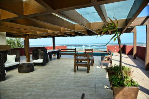 a patio with a table and chairs and the ocean at De Rose Praia Hotel in Torres