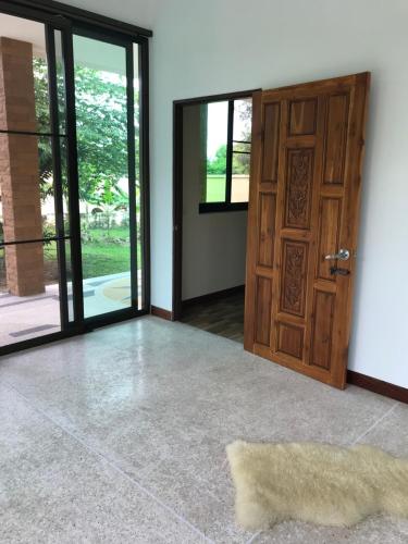 an empty room with a door and a rug at House of Garden in Chiang Rai