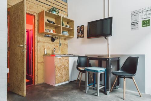 Il comprend une cuisine avec une table et deux chaises ainsi qu'une télévision. dans l'établissement Swanky Mint hostel, à Zagreb
