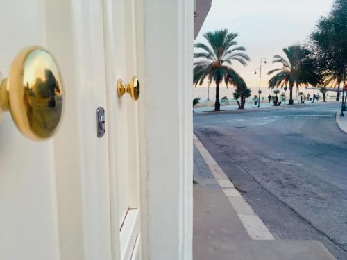 drzwi z widokiem na ulicę i palmy w obiekcie Domus Bianca Lancia w mieście Manfredonia