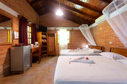 a room with three beds and a kitchen with a desk at Escape Caribeño in Puerto Viejo