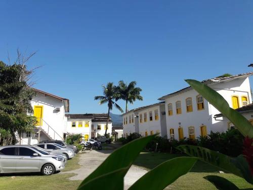 een rij gebouwen met auto's op een oprit bij Pousada Fortaleza in Paraty