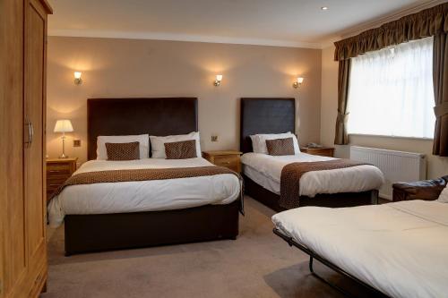 a hotel room with two beds and a window at Higher Trapp Hotel in Padiham