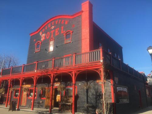 a red building with a sign on the side of it at The Cochrane Rockyview Hotel in Cochrane