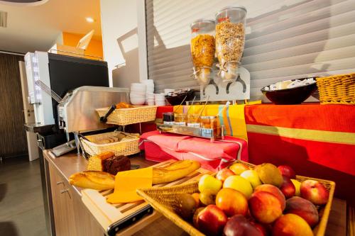 un buffet con cestas de fruta en una mesa en Appart-Hôtel Mer & Golf City Perpignan Centre, en Perpiñán