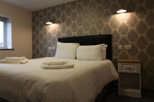 a bedroom with a large bed with two towels on it at The Kingstanding Inn in Birmingham