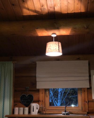 a light hanging over a window in a kitchen at Log home village in Ulverston