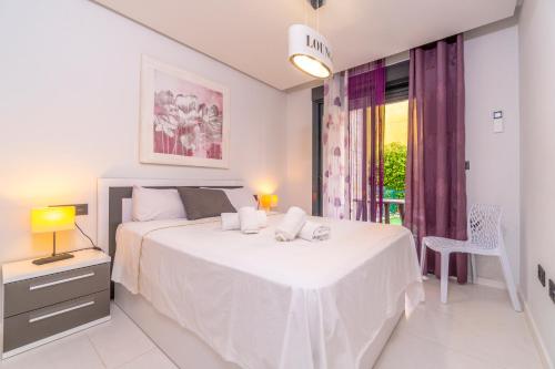 a white bedroom with a large bed and a window at Bennecke Niagara in Cabo Roig