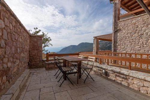 una mesa y sillas en un patio con vistas en Kallisto Mountain House III, en Arachova