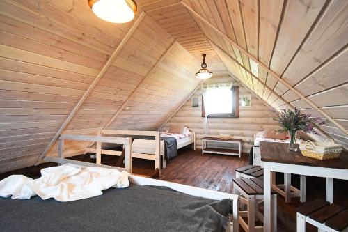a attic room with two beds in a wooden cabin at klub Karino 2 in Mikołajki
