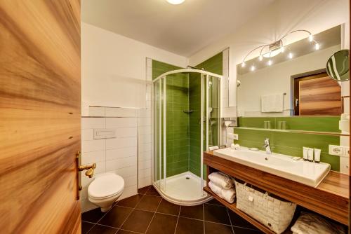 a bathroom with a sink and a shower and a toilet at Apartments Bachmair in Schenna