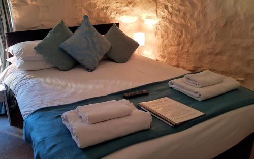 a bed with two folded towels on top of it at Crown Inn in Rhayader