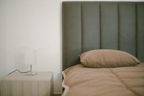 a bed with a green headboard and a table with a lamp at Parco d'Arte AltArt in Rende