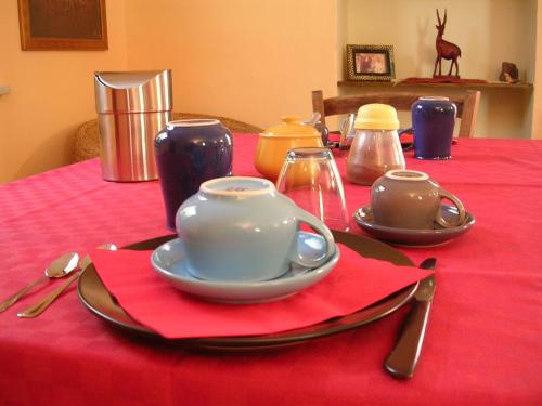 uma mesa vermelha com um conjunto de chá sobre uma toalha de mesa vermelha em Cappone B&B em Morciano di Romagna