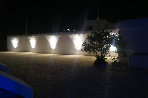 a white wall with lights on it at night at STUDIOSWORX Apartments in Ios Chora