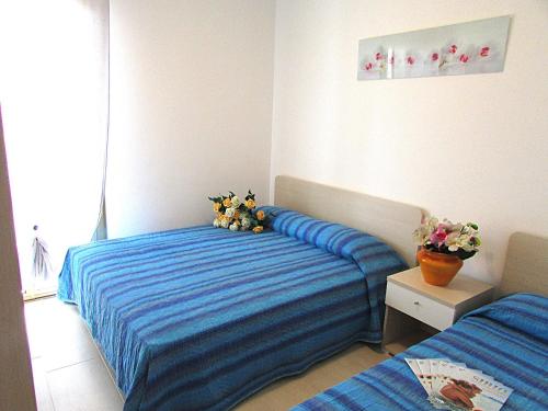a bedroom with two beds with blue sheets at Isi in Bibione