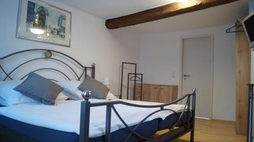 een slaapkamer met een groot bed met witte lakens en blauwe kussens bij Ferienwohnung Frieda in Hungen