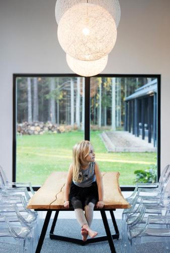 a young girl sitting on a table in front of a window at Hõbekala Guesthouse in Kalana