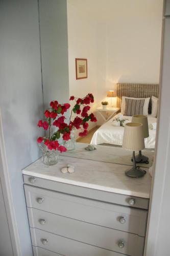 a bedroom with a dresser with red flowers on it at Bakagiannis Apartments in Parga