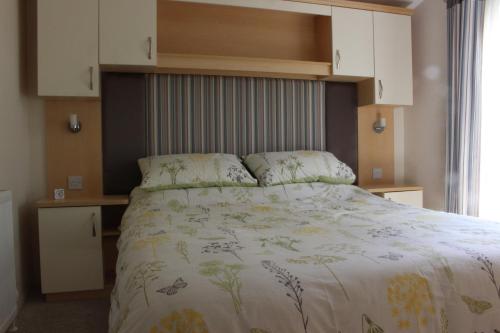 1 dormitorio con 1 cama con colcha blanca en Ben View, en Taynuilt