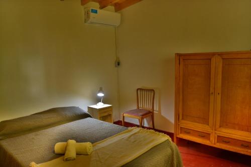 La Casa de Huéspedes في سانتا تيريسيتا: غرفة نوم مع سرير مع دمية دب عليها
