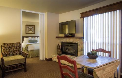 a living room with a bed and a table and a fireplace at Elkhorn Village in Sun Valley