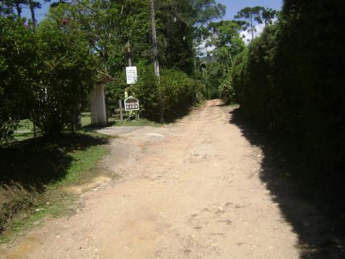 a dirt road with trees and a sign on it at Chalé charmoso e aconchegante em Visconde de Maua in Visconde De Maua