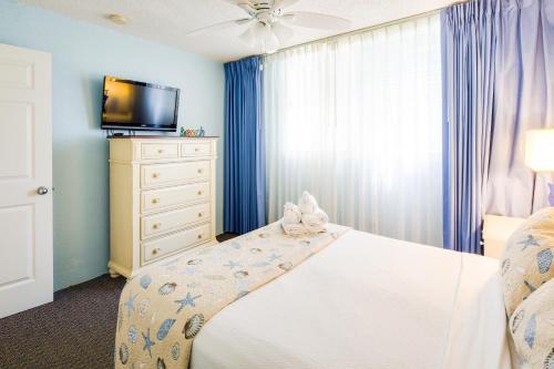 a bedroom with a white bed and a tv at Sunrise Suites Saint Lucia Suite #201 in Key West