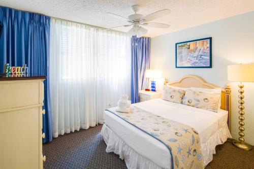 a bedroom with a large bed with blue curtains at Sunrise Suites Saint Lucia Suite #201 in Key West