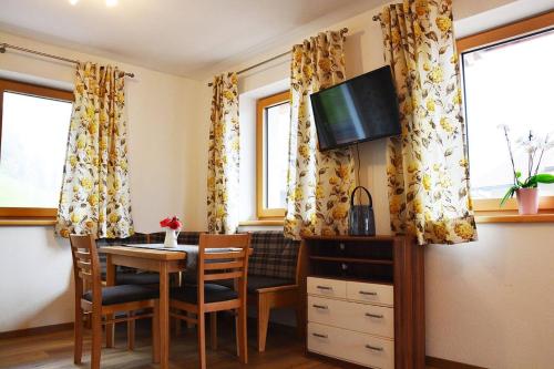 a dining room with a table and chairs and windows at Niederstallnhof in Sankt Johann im Pongau