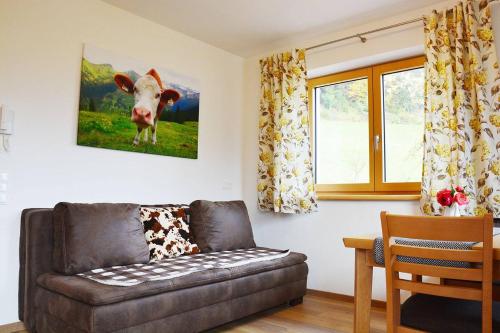 a living room with a couch and a cow on the wall at Niederstallnhof in Sankt Johann im Pongau