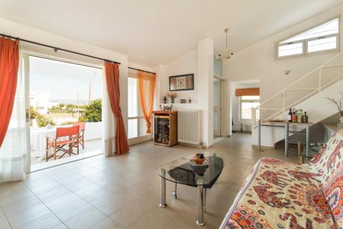Una sala de estar con un sofá y una mesa de cristal. en Holiday home next to orange tree orchard, en Vrachati