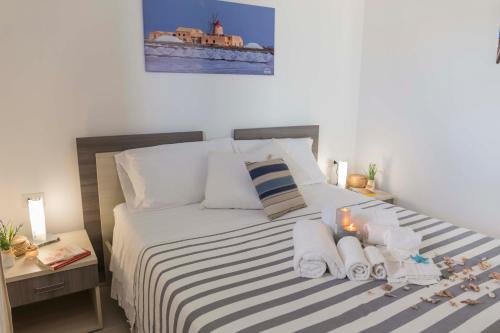 a bedroom with a bed with towels and candles on it at MareinSicilia: Talia Residence in Sampieri