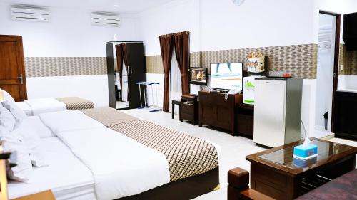 a hotel room with two beds and a television at BeOne House Jogja in Yogyakarta