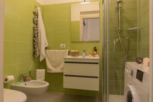 a green bathroom with a sink and a shower at MareinSicilia: Talia Residence in Sampieri