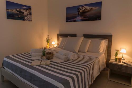 a bedroom with a large bed with a striped blanket at MareinSicilia: Talia Residence in Sampieri