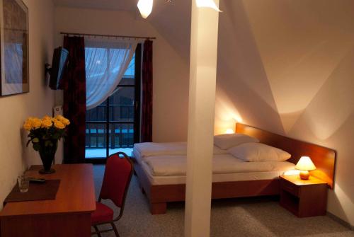 a bedroom with a bed and a desk and a window at Willa Agnieszka in Kazimierz Dolny