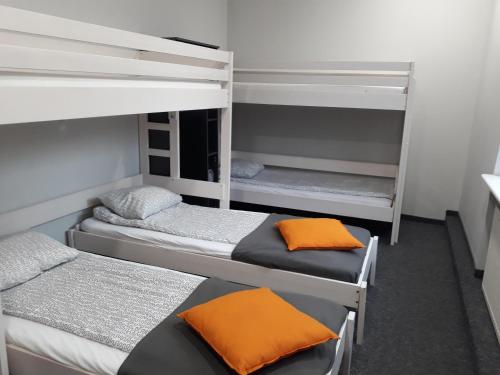 Habitación con 3 literas con almohadas de color naranja en Hostel Sopot Centrum en Sopot