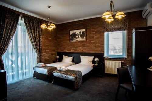 - une chambre avec un lit et un mur en briques dans l'établissement Trzy Korony Boutique Hotel&SPA Piwne, à Puławy