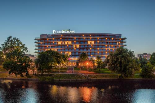 a building with a sign on it next to a lake at Crystal House Suite Hotel & SPA in Kaliningrad