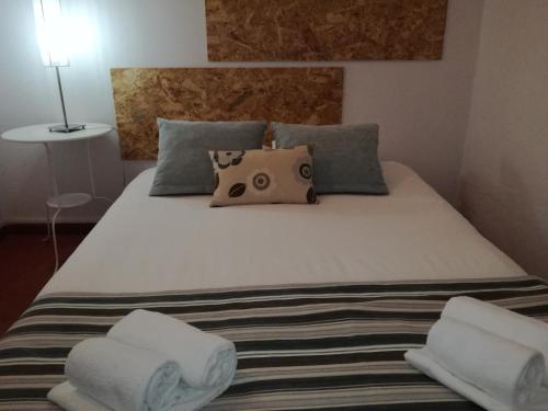 a bed with two towels and a pillow on it at Pro Touristic Montejunto Villas in Arieiro
