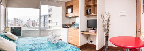 a bedroom with a bed with a red table and a window at Zenteno Apartments in Santiago