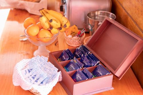 un tavolo in legno con una scatola di cibo e un cesto di frutta di Hostal Los Teros a Coihaique