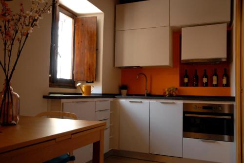 una cucina con armadi bianchi e un tavolo con bottiglie di vino di Antica Dimora I Dragoni a Cagliari