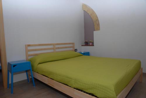 een slaapkamer met een groen bed en een blauwe tafel bij Antica Dimora I Dragoni in Cagliari