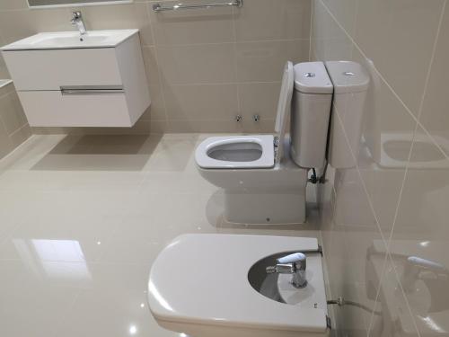 a white bathroom with a toilet and a sink at Pinares de Higuerillas in Maitencillo