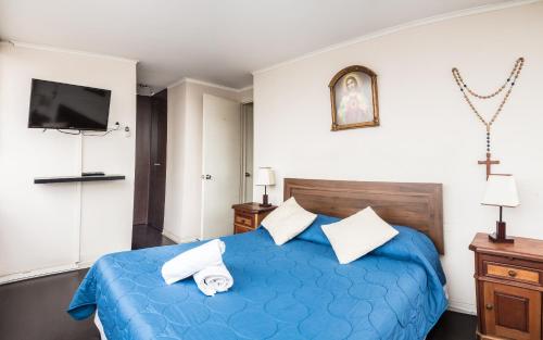 a bedroom with a blue bed and a tv at Zenteno Apartments in Santiago