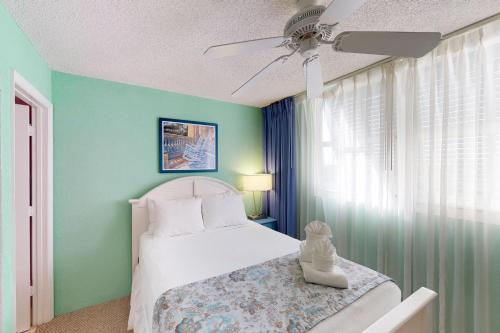 基韋斯特的住宿－Sunrise Suites Catalina Suite #311，一间卧室配有一张床和吊扇